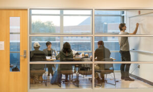 Adult students in glass study room