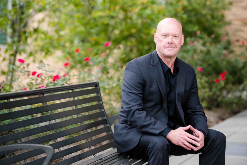 Chris Steele on a garden bench on the UMBC campus.